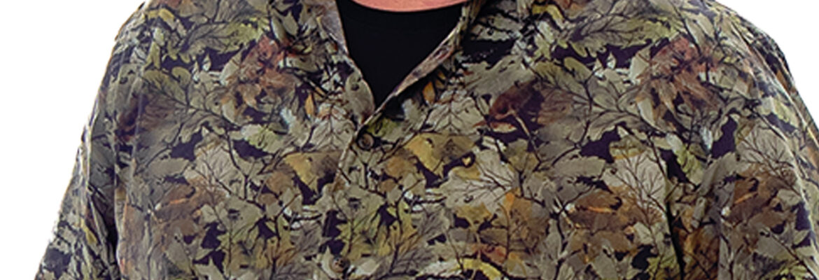 Jan Smeets kijkt je breedlachend aan. Hij draagt een groene blouse met motief.