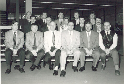 Oude zwart-wit foto van JAN-leden zittend op een rij